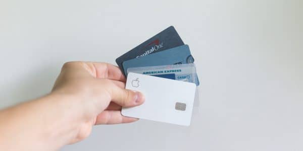 A photo of a hand holding four credit cards.